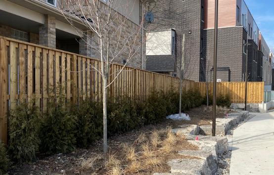 Custom wood fencing style built along the outside of an apartment building called Board on Board wood fence.